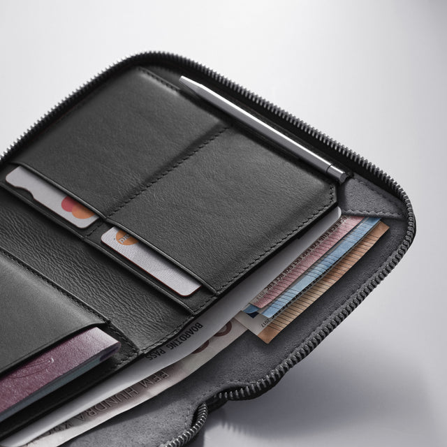 WOOLNUT Premium leather passport wallet designed to organize travel documents, boarding passes, cards, and currency black leather