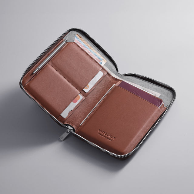 WOOLNUT cognac brown Leather travel folio with zip closure, featuring organized storage for passports, boarding passes, cards, cash, travel documents, and a mini pen