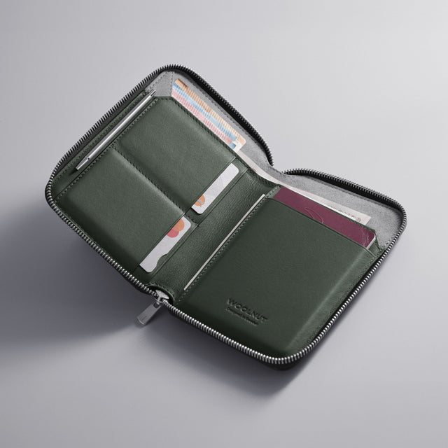 WOOLNUT green Leather travel folio with zip closure, featuring organized storage for passports, boarding passes, cards, cash, travel documents, and a mini pen