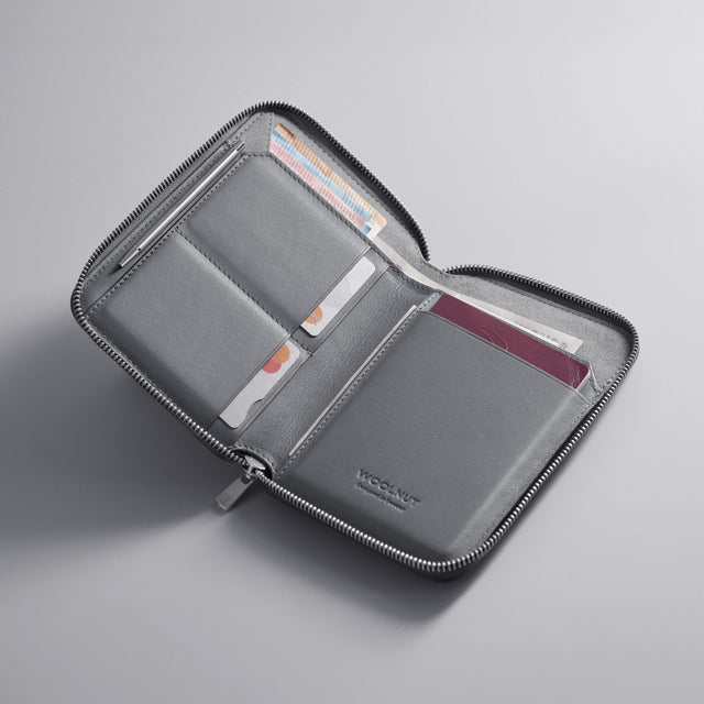 WOOLNUT Grey Leather travel folio with zip closure, featuring organized storage for passports, boarding passes, cards, cash, travel documents, and a mini pen